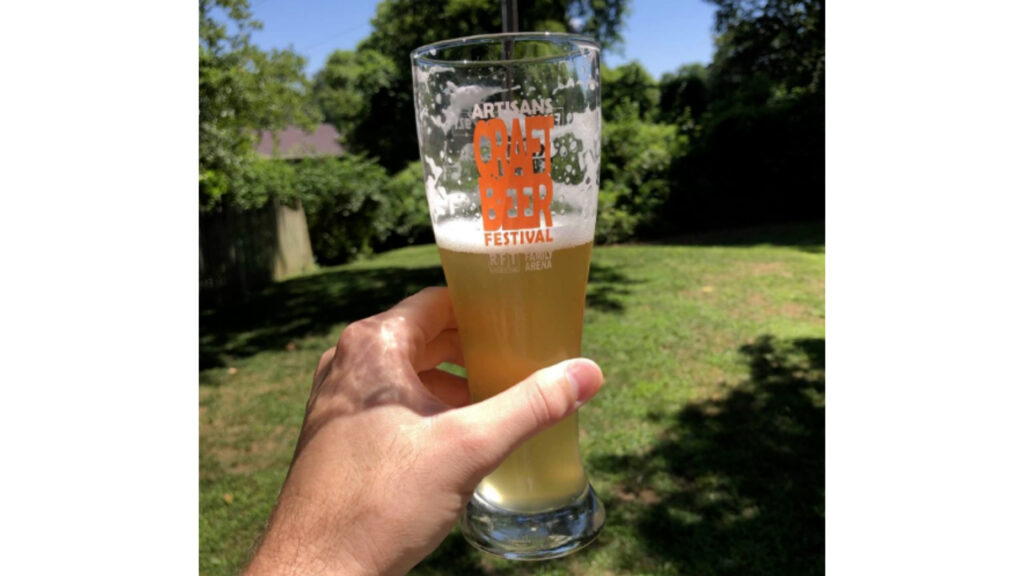 glass of piwo grodziskie beer in sunny backyard